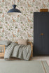 A cozy kids’ room features a small wooden bed with checkered bedding, gray pillow, dark wardrobe, and vibrant African Safari Wallpaper showcasing elephants, giraffes, and birds. A blue pendant lamp hangs overhead.