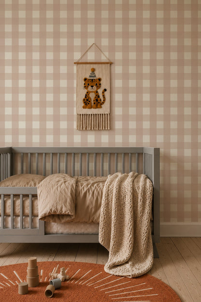 A nursery with Large Check Wallpaper, Pink, a gray crib, a hanging wall tapestry of a leopard wearing a party hat, and a circular orange rug with wooden toys.
