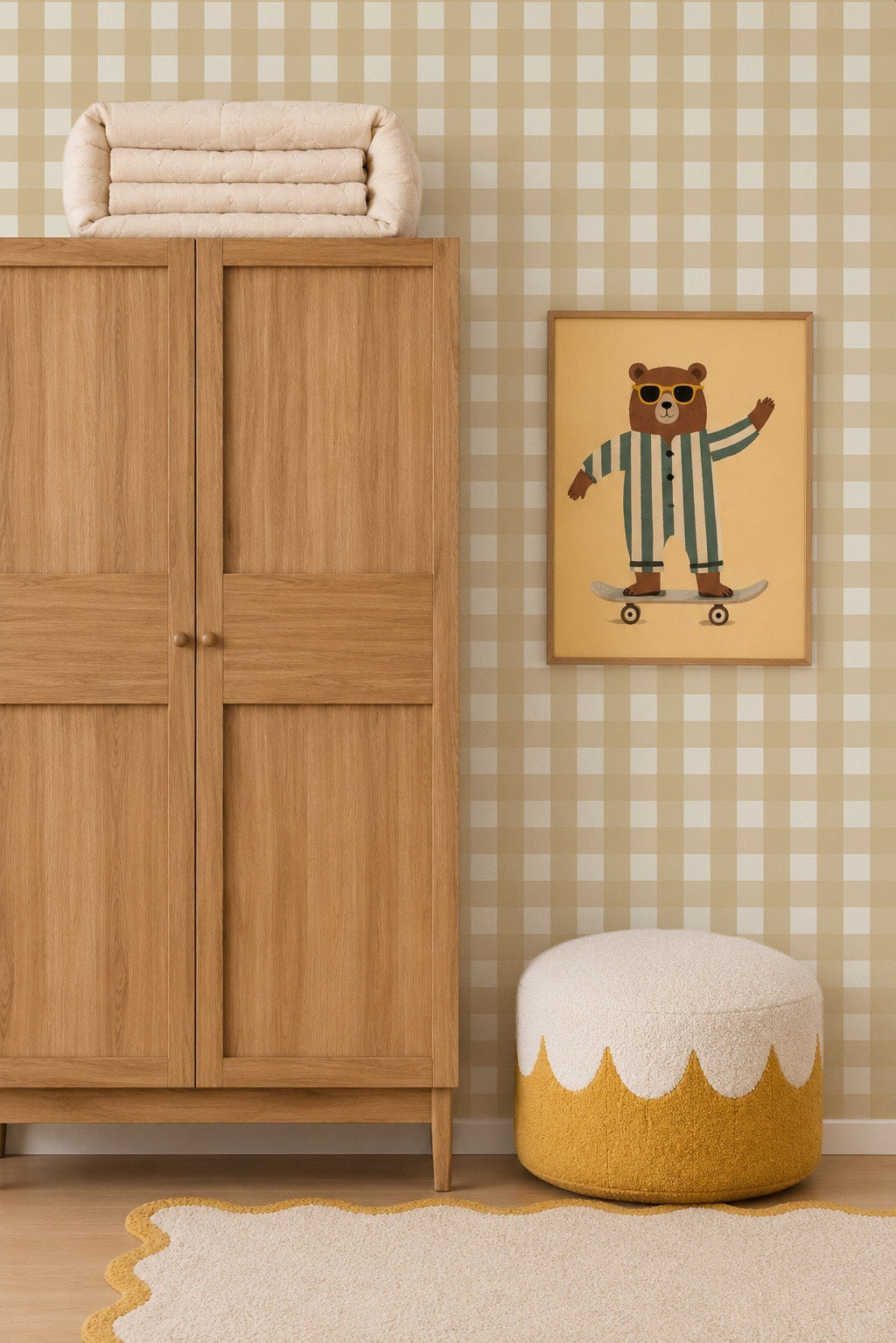 A framed wall print of a bear wearing sunglasses and striped pajamas riding a skateboard, positioned next to a wooden wardrobe and a textured ottoman in a room with Large Check Wallpaper, Yellow.