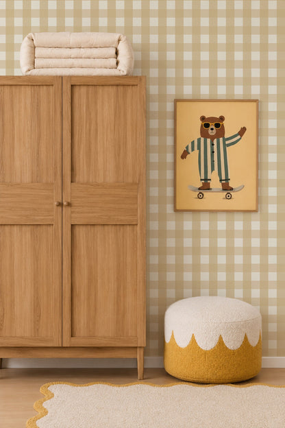 A framed wall print of a bear wearing sunglasses and striped pajamas riding a skateboard, positioned next to a wooden wardrobe and a textured ottoman in a room with Large Check Wallpaper, Yellow.