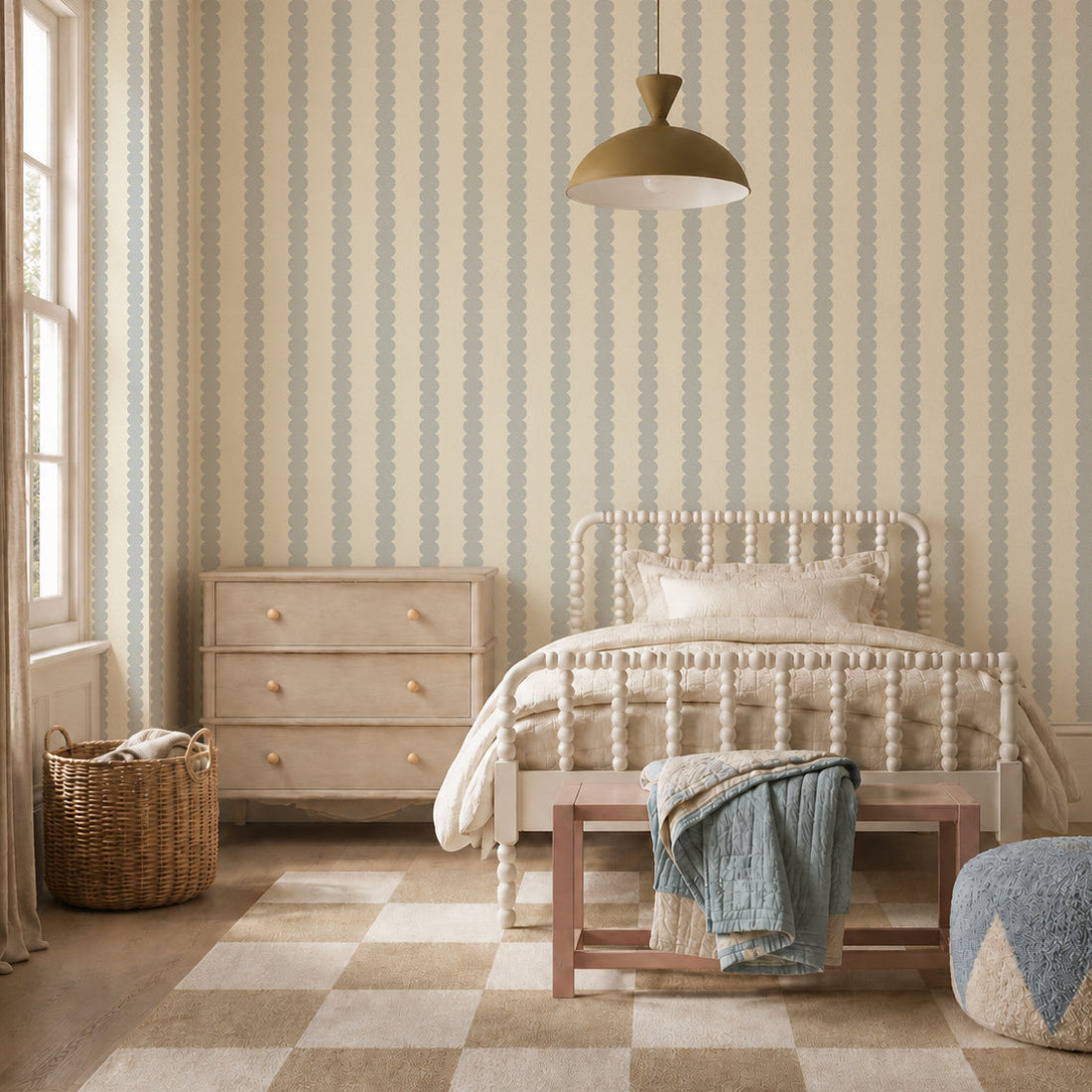 A cozy bedroom with a light wood bed, beige checkered rug, wooden dresser, and wicker laundry basket. The walls feature Scallop Stripe Wallpaper in Blue, and a blanket is draped over a bench at the foot of the bed.