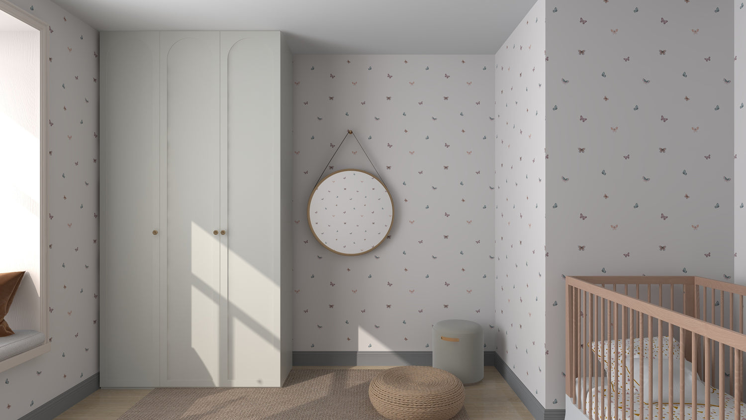 A minimalist nursery features a wooden crib, round mirror on Bibi Butterflies Wallpaper by munks and me, and a pale green wardrobe. A beige woven rug and small stool complete the scene as light filters through the window, embodying an online imagery sample come to life.