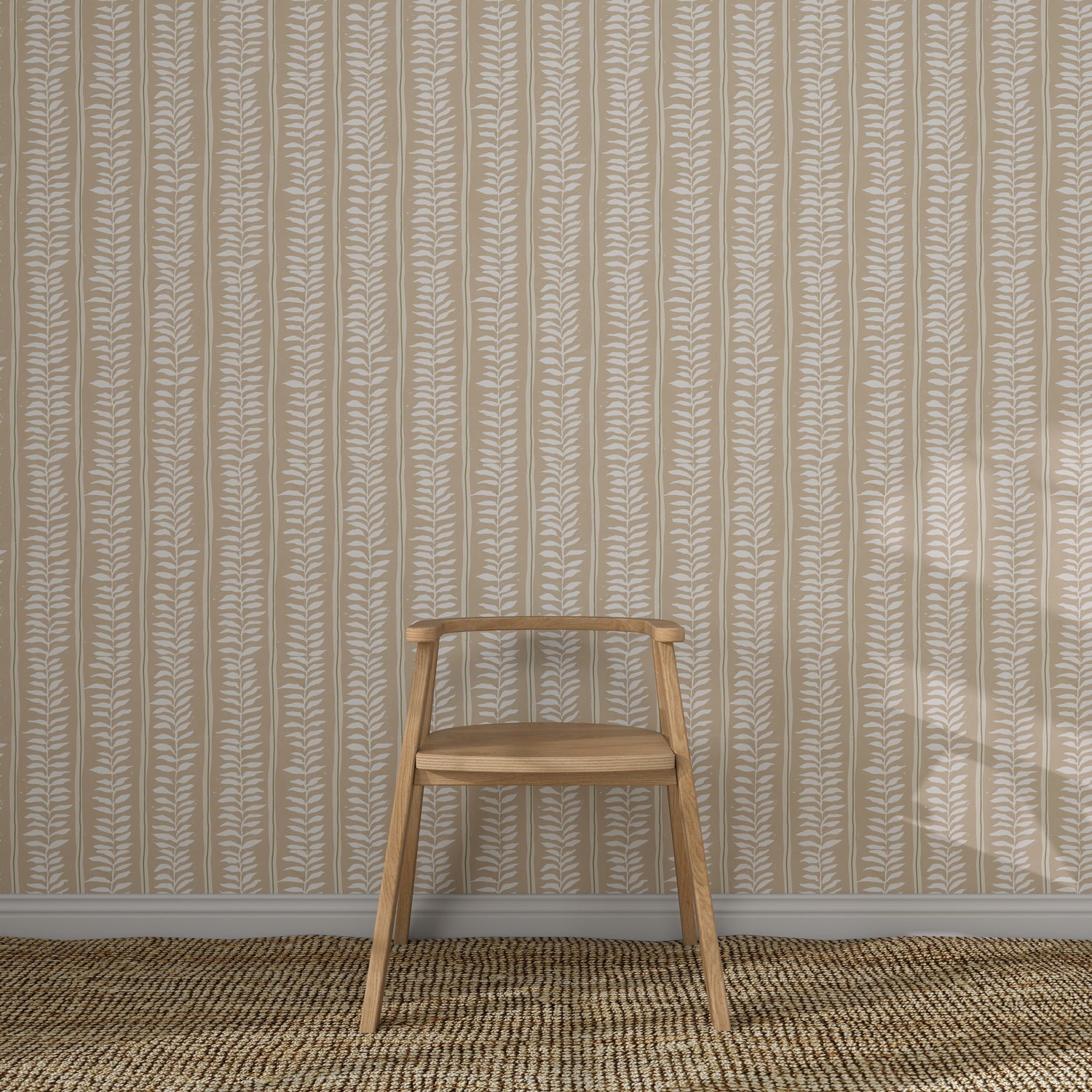 A simple wooden chair rests on a woven rug before a beige wall featuring Meadow Leaf Stripe Wallpaper in Clay, creating a minimal and uncluttered scene.