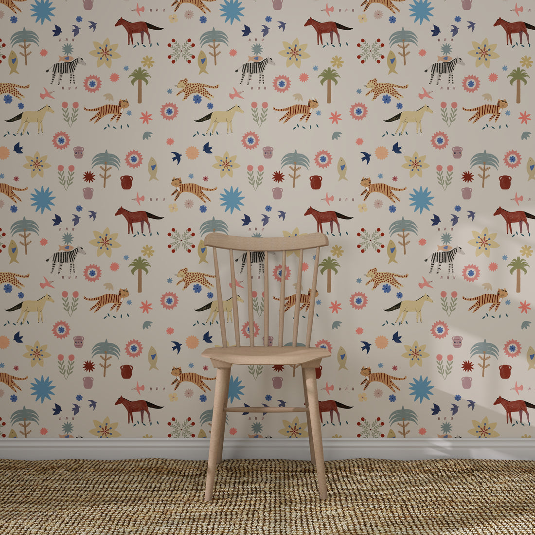 A wooden chair rests on a woven rug in front of the colourful Little Wanderers Wallpaper Sample, which features playful illustrated animals like zebras, cheetahs, tigers, and horses among whimsical trees and flowers.