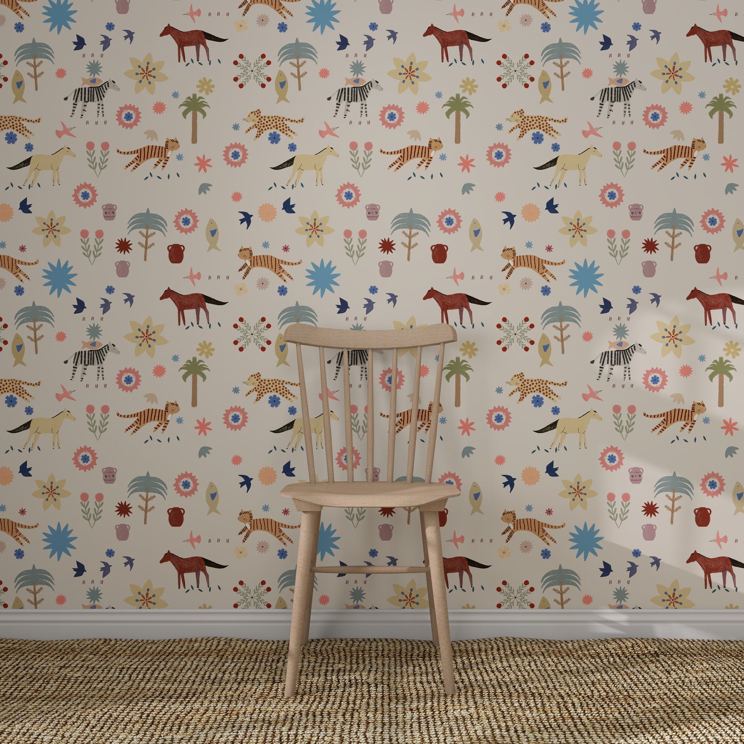 A wooden chair rests on a woven rug in front of the colourful Little Wanderers Wallpaper Sample, which features playful illustrated animals like zebras, cheetahs, tigers, and horses among whimsical trees and flowers.