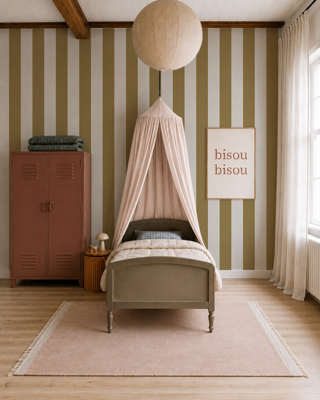 A cozy children’s bedroom with Circus Stripe Wallpaper, Moss, a single bed under a soft pink canopy, round beige light overhead, red locker, bedside table with lamp, and a “bisou bisou” sign on the wall.