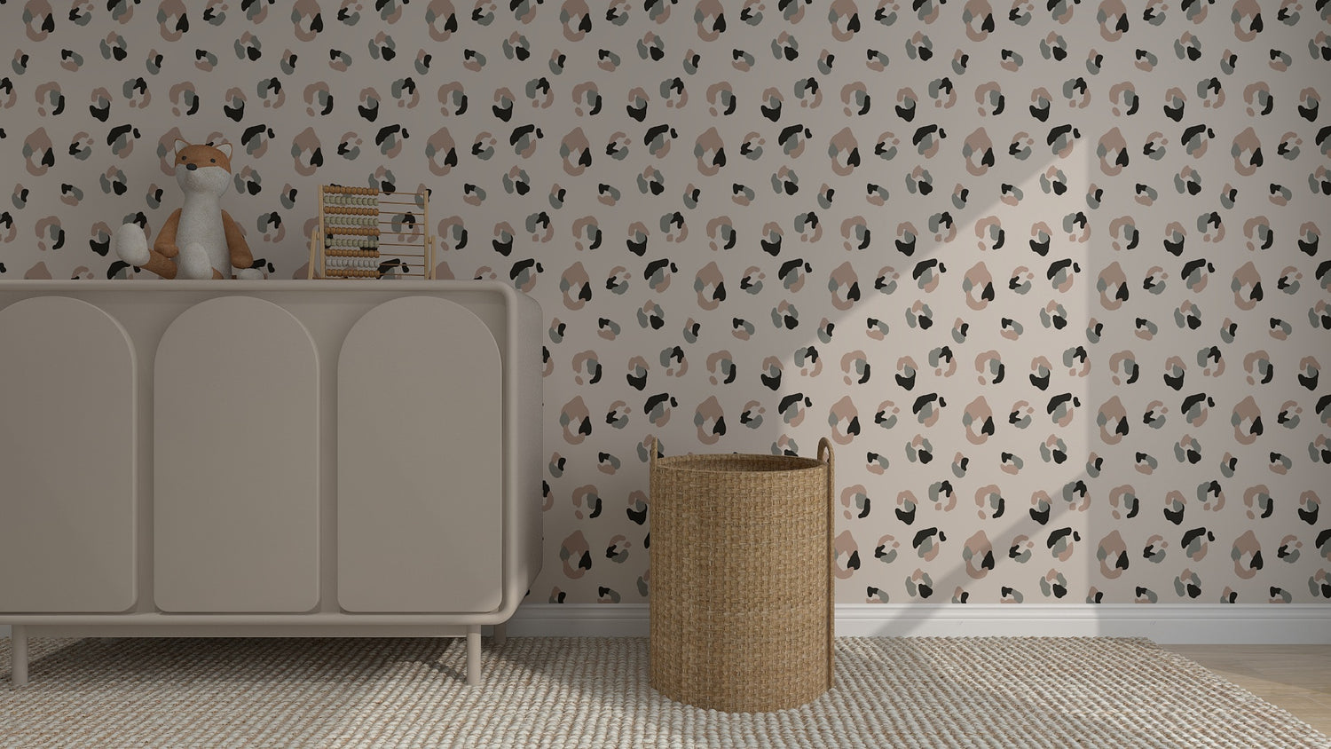 A nursery features a beige dresser topped with a toy fox and books, a wicker basket, and elegant Yara Leopard Print Wallpaper in muted tones. A textured rug completes the warmth of this cozy home decor space.