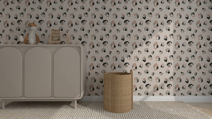 A nursery features a beige dresser topped with a toy fox and books, a wicker basket, and elegant Yara Leopard Print Wallpaper in muted tones. A textured rug completes the warmth of this cozy home decor space.