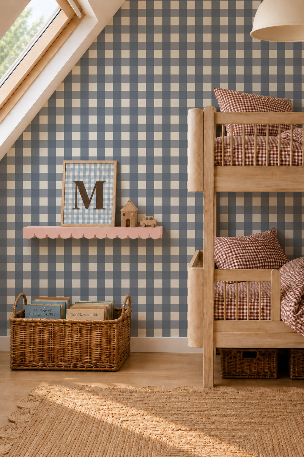 A child’s bedroom featuring Large Check Wallpaper, Deep Blue, a wooden bunk bed with red gingham bedding, and a pink scalloped shelf holding a framed letter M.