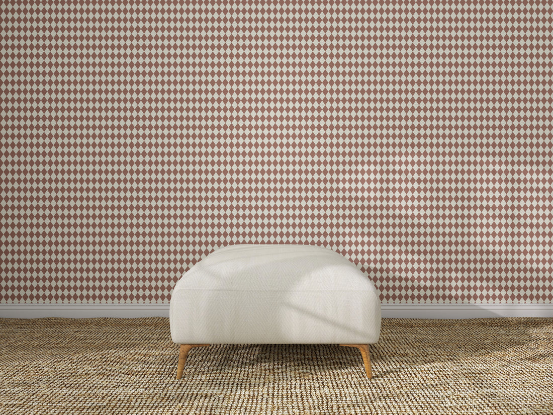 A white cushioned bench with wooden legs sits on a beige woven rug, set before a wall decorated with Diamond Dancer Wallpaper in the Stone Rose colorway.