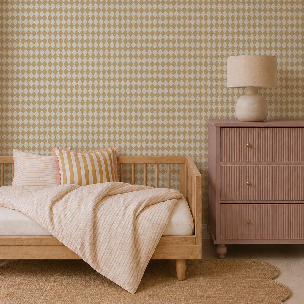 A cozy bedroom with a wooden bed, beige-striped bedding and pillows, a pinkish-brown dresser topped with a round lamp, a scalloped jute rug, and striking Diamond Dancer Wallpaper in yellow.