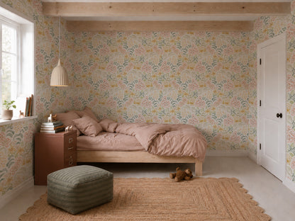 Cozy bedroom featuring Floret Dreamscape Wallpaper in pastel florals, a wooden bed with pink bedding, a brown nightstand, a hanging lamp, window with plants, a jute rug, green ottoman, and a teddy bear on the floor.