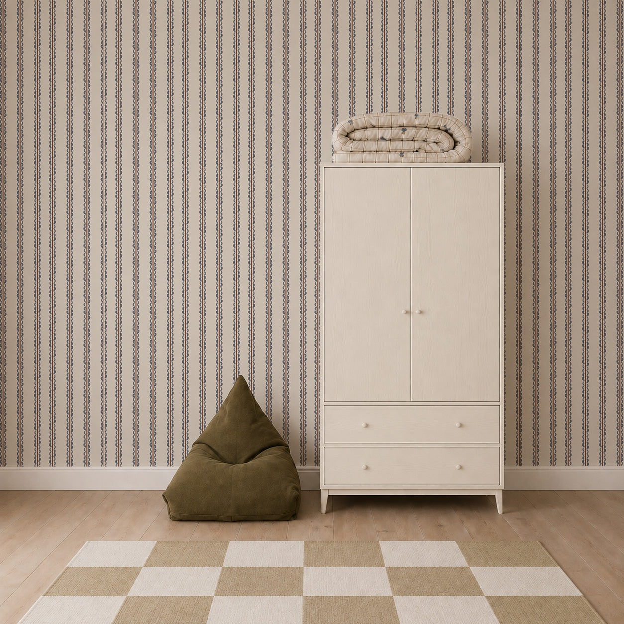 Minimalist room featuring the Folk Scallop Stripe Wallpaper in Chambray &amp; Mocha, a white wardrobe with folded blankets on top, a green bean bag chair, and a beige-checkered rug on a wooden floor.