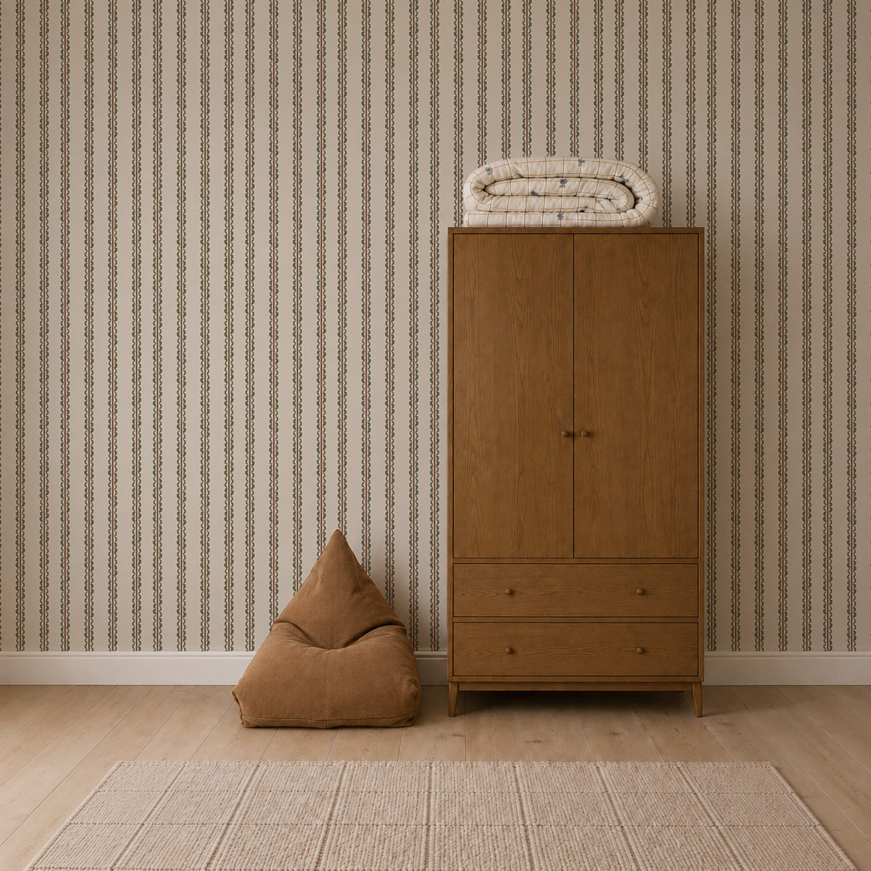 A brown bean bag, a wooden wardrobe with two drawers, and a folded blanket on top sit against Folk Scallop Stripe Wallpaper in Olive &amp; Mocha, complemented by a light-colored rug on a wooden floor.