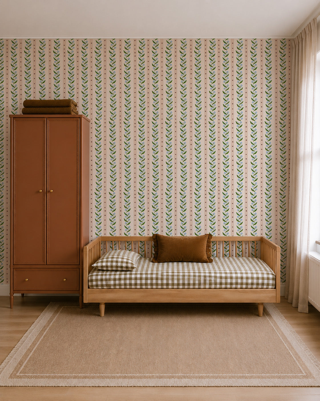 A bedroom featuring a daybed and wardrobe set against Forget-Me-Not Trail Stripe Wallpaper, which features a vertical pattern of pink stripes alternating with blue forget-me-not flowers and green leaves.