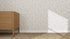 A wooden dresser with three drawers stands on a textured carpet beside a wall decorated with Hallie Leopard Print Wallpaper Repeat Pattern in beige, as sunlight casts a triangular shadow on the wall.