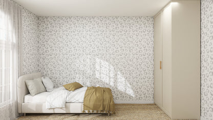 Minimalist bedroom with a low beige bed, white and beige bedding, a woven rug, built-in cream wardrobe, and whimsical walls featuring Hallie Leopard Print Wallpaper Repeat Pattern in charcoal. Sunlight filters through sheer curtains on the left window.