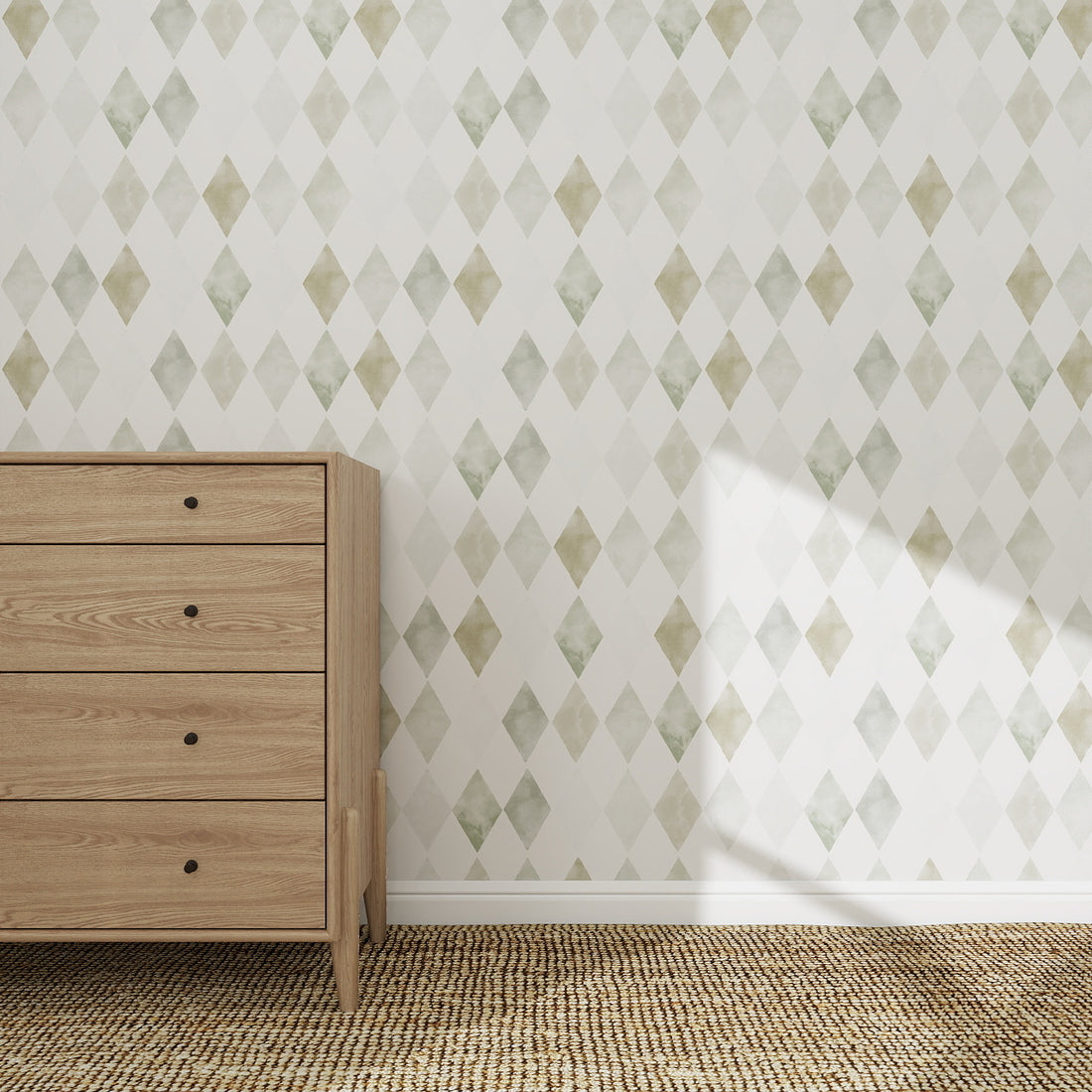 A wooden dresser with four drawers stands on a woven rug against a white wall adorned with Harlequin Watercolour Wallpaper Repeat Pattern in green. Sunlight casts delicate shadows on the patterned wall and floor.