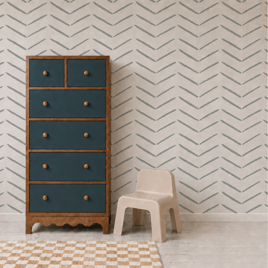 A tall wooden dresser with blue drawers stands beside a small beige plastic chair in a room decorated with Herringbone Wallpaper, Blue, and featuring a checkered rug on the light wooden floor.