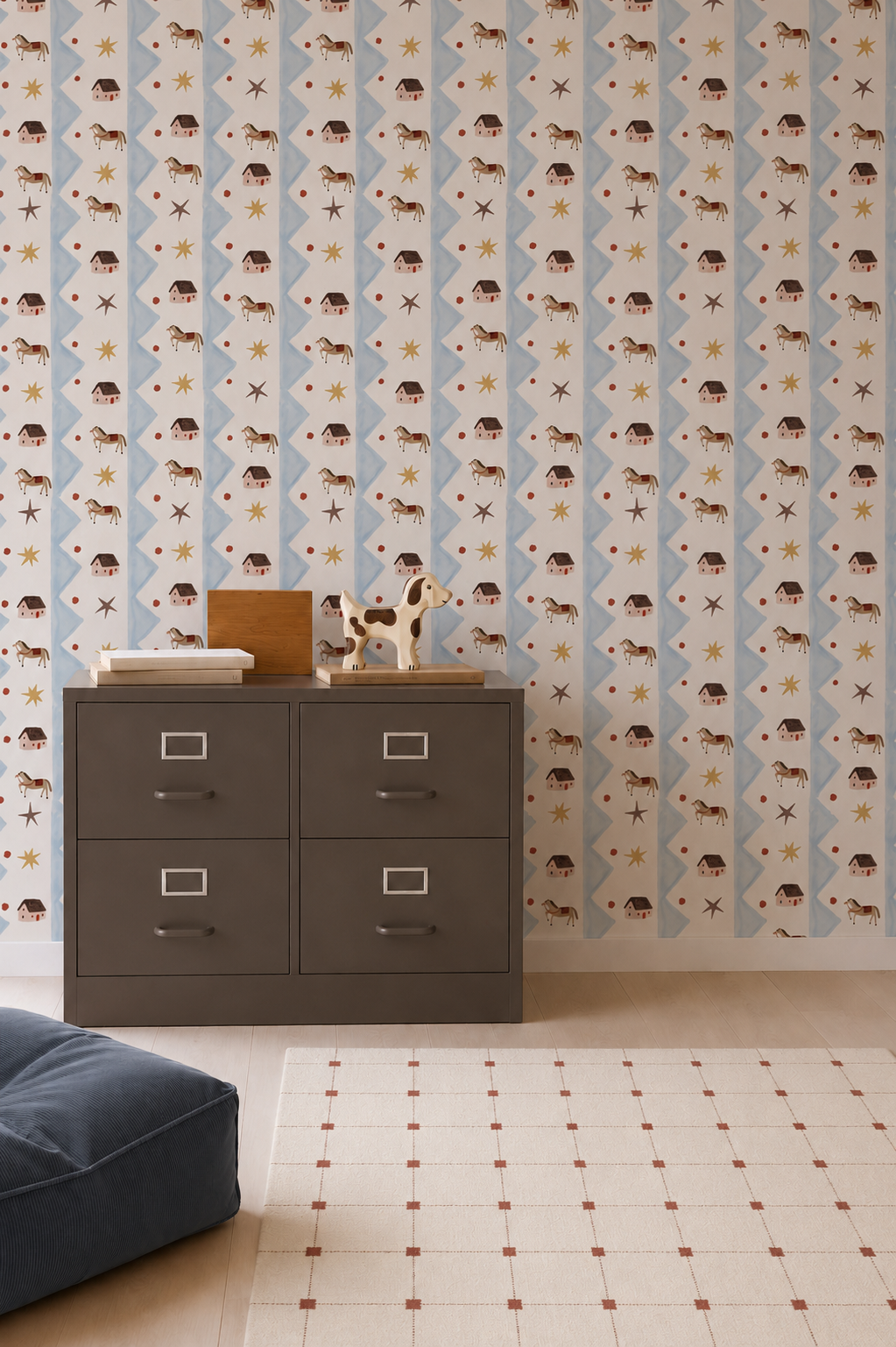 A small dresser with animal toys sits against a wall covered in Paddock Parade Wallpaper Sample, which features buffalo and star motifs and showcases exceptional quality. On the floor, there is a blue cushion and a white rug with a simple grid pattern.