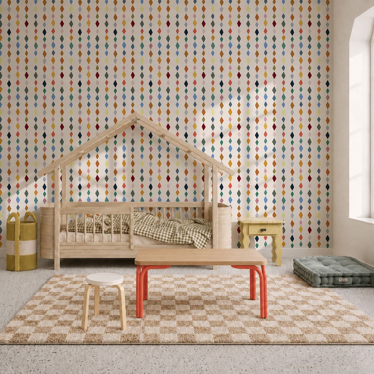 A children’s bedroom featuring Jolly Jester Wallpaper, Multi with a vertical pattern of colorful diamonds, a house-shaped bed, a low table, and a checkered rug.