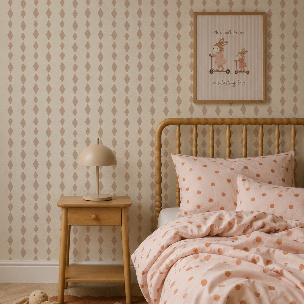 Cozy bedroom with a wooden bed, polka dot bedding, matching rug, small wooden nightstand with a beige lamp, and a framed cute animal print on charming Jolly Jester Wallpaper in pink.