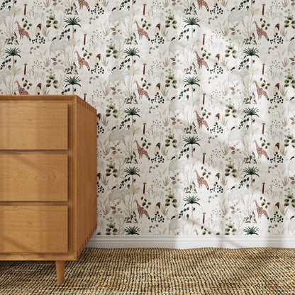 A wooden dresser sits on a textured woven rug. Behind it, the Jungle Dreams Wallpaper Repeat Pattern displays playful giraffes, elephants, palm trees, and plants in soft neutral tones.