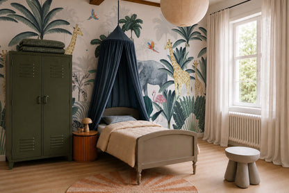 A cozy kids room featuring a Jungle Mural with playful safari animals, a single bed under a blue canopy, green locker, round side table, soft rug, and large window with sheer curtains letting in natural light.