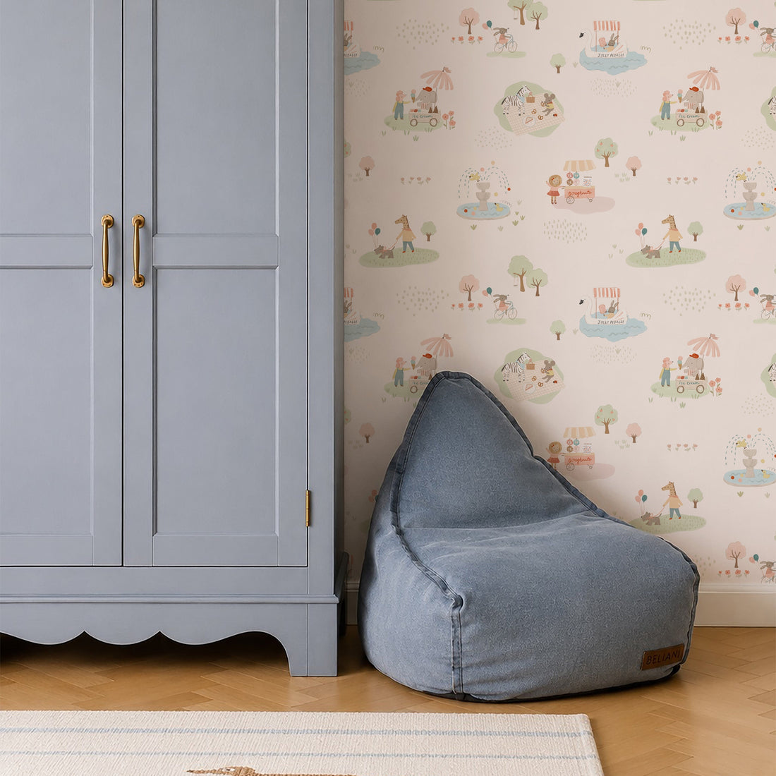 A light blue wardrobe with gold handles stands beside a blue bean bag chair on a wood floor, against a wall decorated with Little Friends Day Out Wallpaper. A wicker basket sits atop the wardrobe.