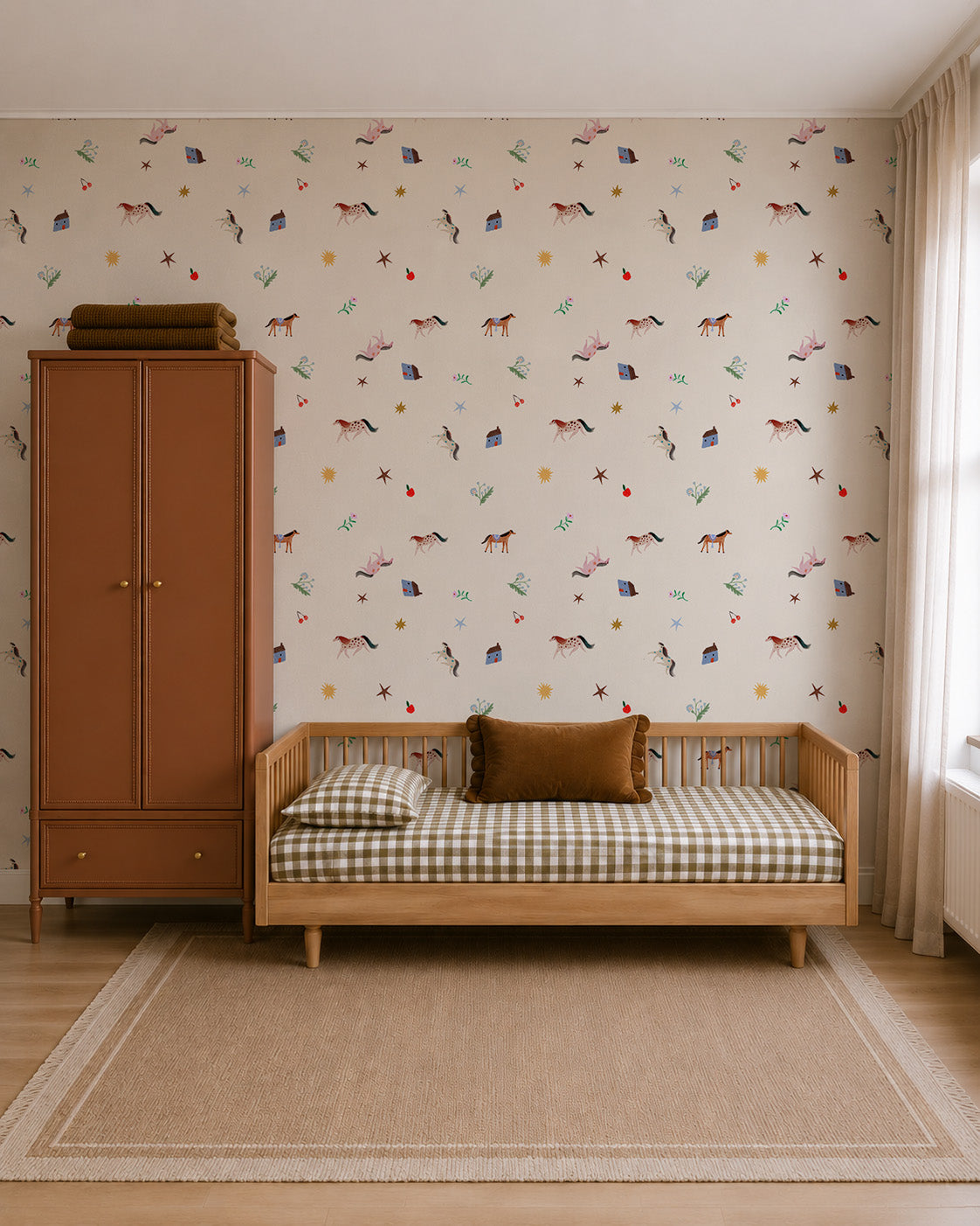 A child’s room featuring Little Paddock Wallpaper with horse, house, and star motifs, a wooden daybed, and a tall storage cabinet.