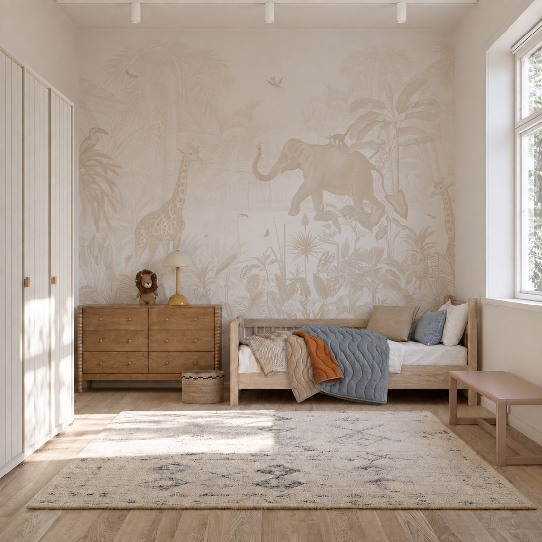 A nursery featuring a neutral-toned Magic Jungle Mural depicting an elephant and giraffe.