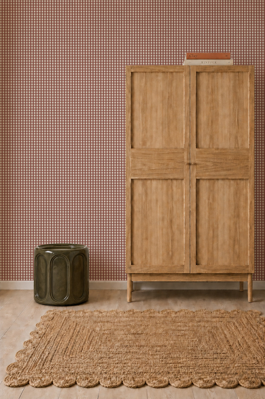 A tall wooden cabinet stands beside a green ceramic side table in front of a wall covered in Mini Check Wallpaper, Red.
