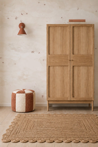 Opals Sky Birds Mural, Sand, featuring small flying birds in earth tones, displayed in a room with a wooden wardrobe, a checkered ottoman, and a braided rug.