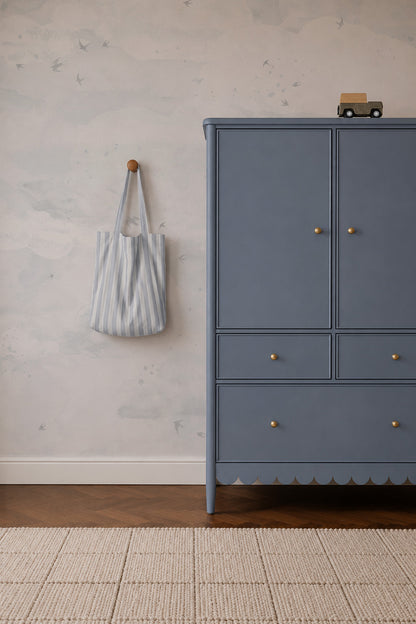 Blue cabinet with gold knobs beside a wall featuring an Opals Sky Birds Mural, Salt, of flying birds.