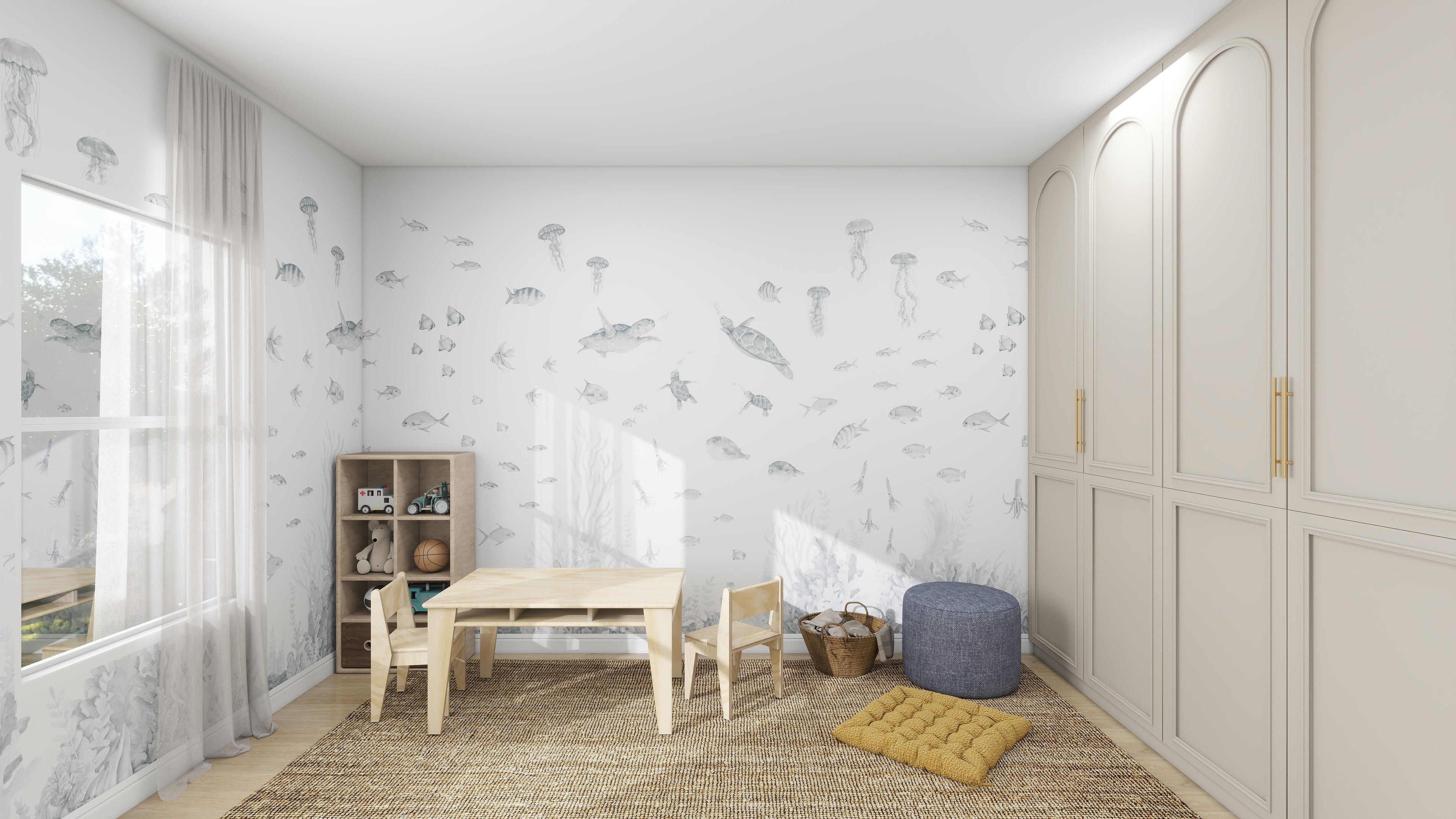The childrens room features the Fish Tank Wallpaper Mural in Blue by munks and me, adorned with sea creatures like jellyfish. A wooden table and chairs sit on a woven rug, next to a bookshelf holding toys beside a pouf. Sunlit curtains highlight the expansive built-in wardrobes along one wall.