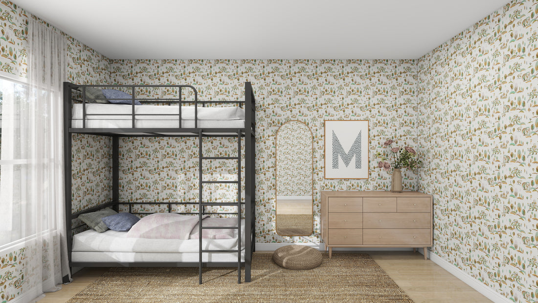 A childrens room displays a metal bunk bed set with white linens, floral wallpaper from munks and mes Winter Bears Repeat Pattern, a wooden dresser topped with a framed letter M and flower vase, a round mirror, and a woven rug on the wooden floor as sunlight streams in through the window.