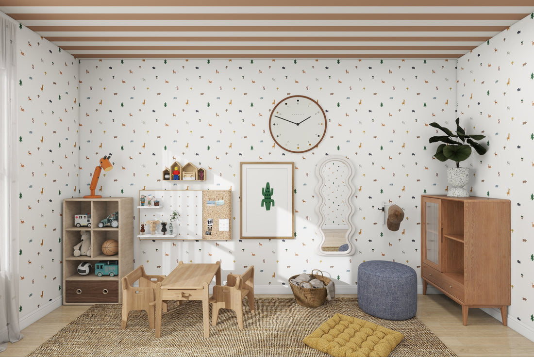 A charming childrens playroom features Tiny Tracks Safari Wallpaper Repeat Pattern by munks and me, a small wooden table with chairs, toy-filled bookshelves, a clock, wall artwork, a cushioned pouf on a yellow rug, and potted plants enhancing the delightful space.