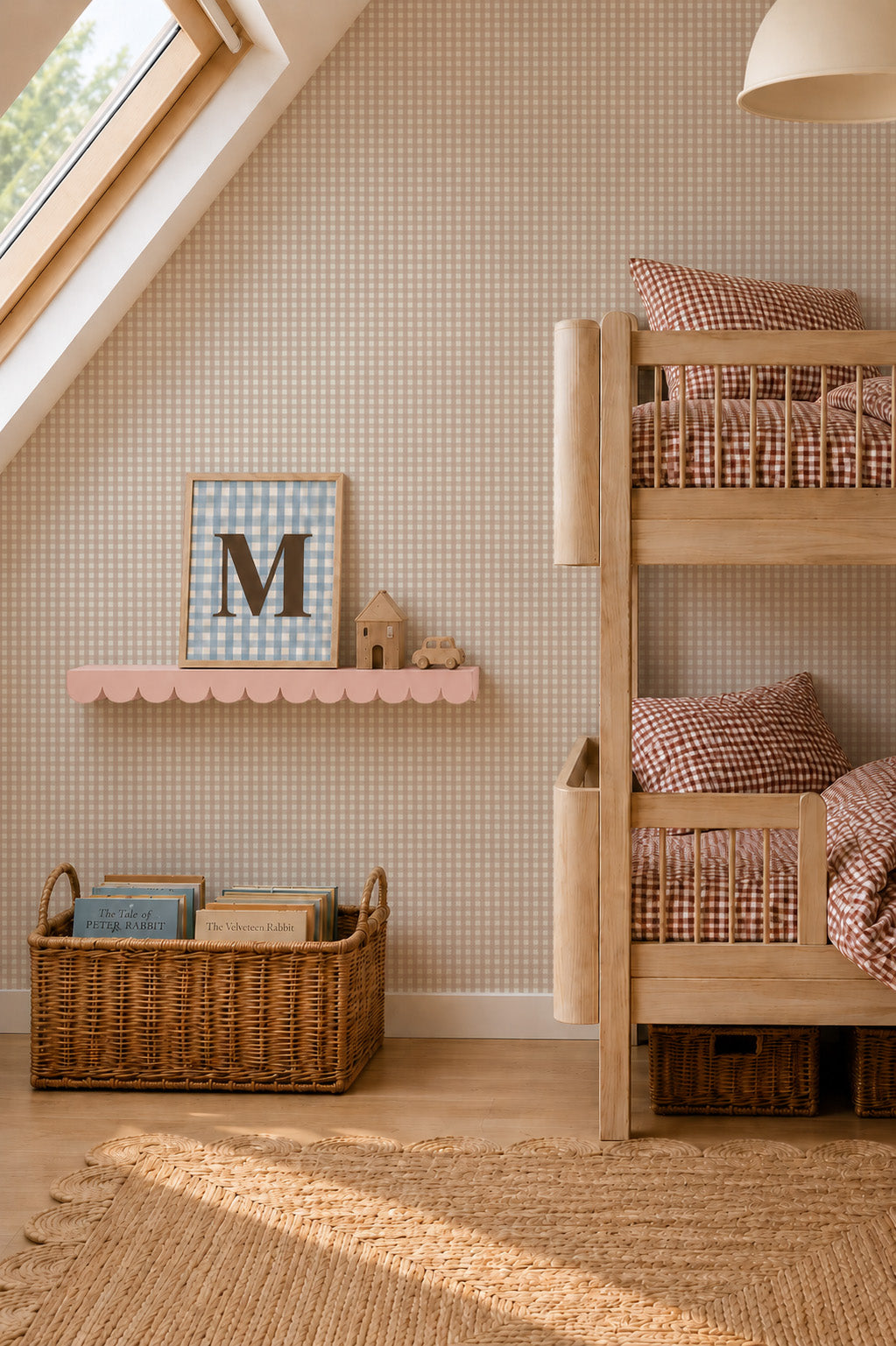 A cozy kids bedroom featuring wooden bunk beds, a basket of books, and a pink shelf displaying decor. Checkered bedding complements the warm light streaming through the skylight, gently illuminating the space and showcasing the playful Mini Check Wallpaper Sample in Pink that adds charm to this inviting atmosphere.