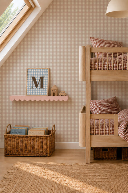A cozy kids bedroom featuring wooden bunk beds, a basket of books, and a pink shelf displaying decor. Checkered bedding complements the warm light streaming through the skylight, gently illuminating the space and showcasing the playful Mini Check Wallpaper Sample in Pink that adds charm to this inviting atmosphere.