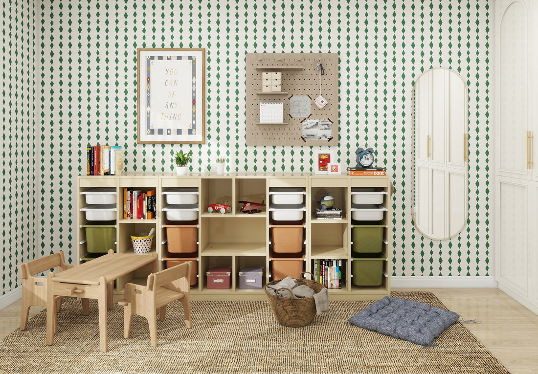 A childrens room includes a wooden table and chairs, storage units with books and bins, a pegboard with items, a framed motivational quote, Jolly Jester Wallpaper Repeat Pattern in green on the wall, plus a cushion and basket for added charm.