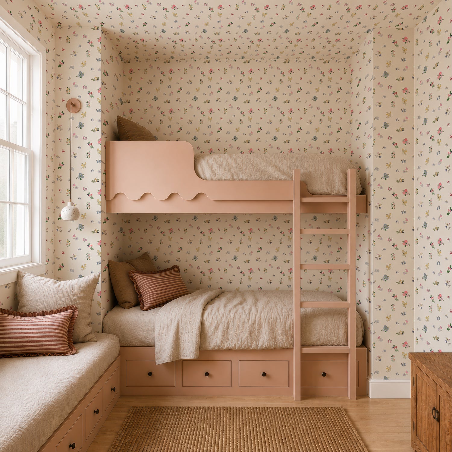 A cozy bedroom featuring peach bunk beds, beige bedding, a striped pillow window seat, built-in drawers, a woven rug on light wood floors, and vibrant Powdered Petals Wallpaper.