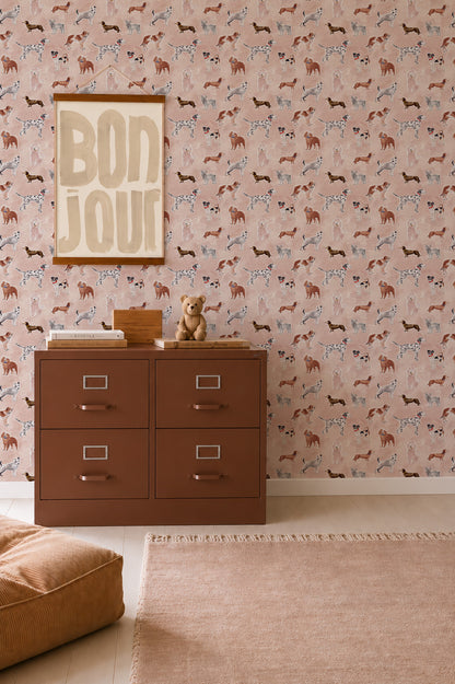 A brown four-drawer filing cabinet sits in front of Rigby Dog Print Wallpaper, Rose, which features small illustrations of various dog breeds.