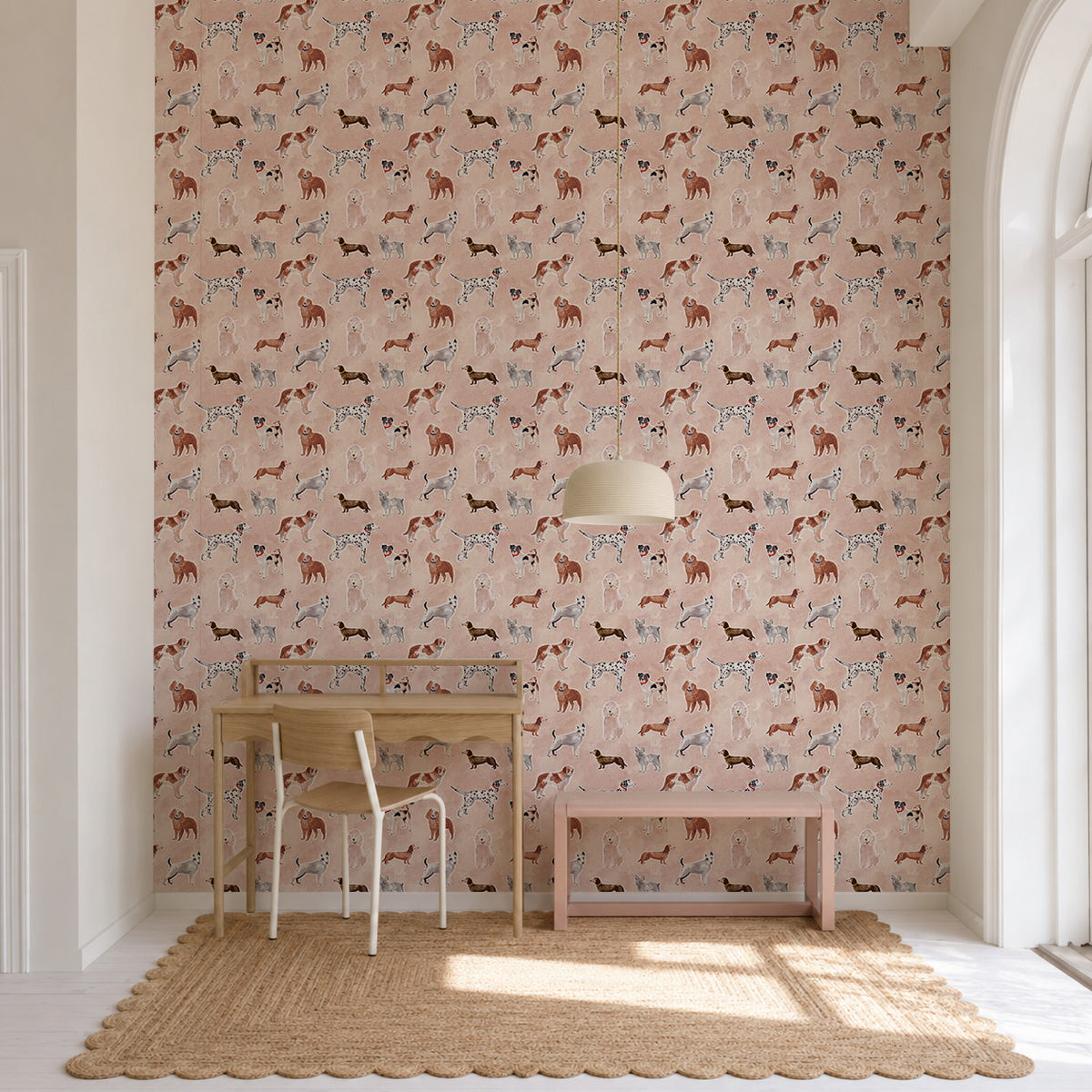Rigby Dog Print Wallpaper, Rose, featuring a handpainted dog print pattern on a rose-colored background, shown in a room with a desk, chair, and bench.