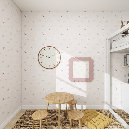 Children’s playroom with small wooden table and stools, a circular wall clock, scalloped-edge mirror, Ruffles Bull Dog Wallpaper Repeat Pattern in Rose with subtle animal prints, and a yellow floor cushion on a woven rug. Sunlight streams in.