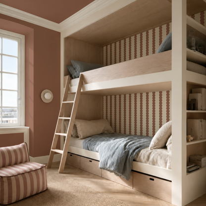 A cozy bedroom featuring light wood bunk beds, blue and beige bedding, a built-in ladder, under-bed drawers, Scallop Stripe Wallpaper in Mocha on an accent wall, a bright window, and a pink striped armchair atop a soft rug.