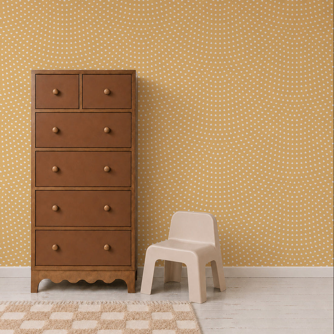 A tall brown wooden dresser stands next to a small, light beige plastic chair, set against the Scallop Shell Mural in yellow with a white polka dot pattern and a light wood floor—perfect for brightening up any kids playroom.