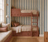 A cozy bedroom features rust-colored bunk beds with built-in drawers, beige bedding, and striped pillows. A window seat sits nearby while Scallop Stripe Wallpaper Sample in Deep Blue adds wavy blue and cream stripes to the walls.
