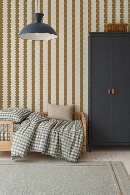 A cozy children’s room features a small wooden bed, checkered bedding, a beige pillow, a tall dark blue wardrobe, and Scallop Stripe Wallpaper in Moss. A large blue pendant lamp hangs overhead.