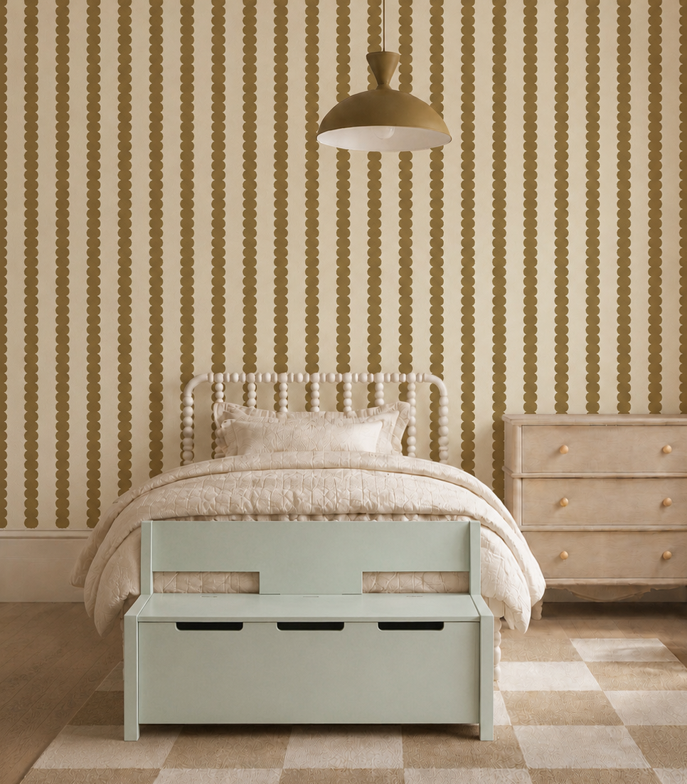 A cozy bedroom with Scallop Stripe Wallpaper in moss, a cream bed with textured bedding, a pastel green storage bench, wooden dresser, geometric rug, and a gold pendant lamp overhead.