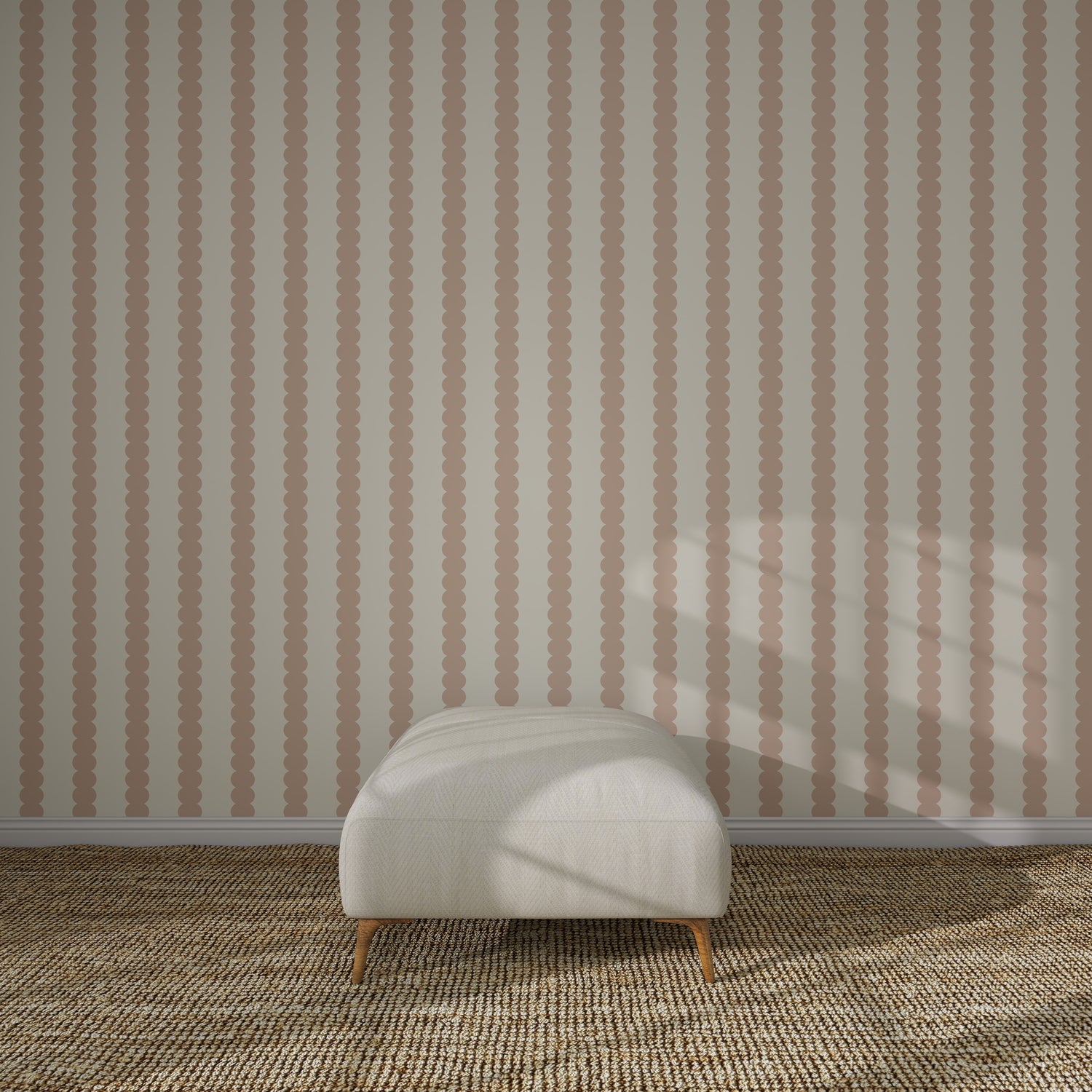 A white cushioned ottoman sits on a textured beige carpet in front of Scallop Stripe Wallpaper Pink. Sunlight casts soft shadows across the scene.